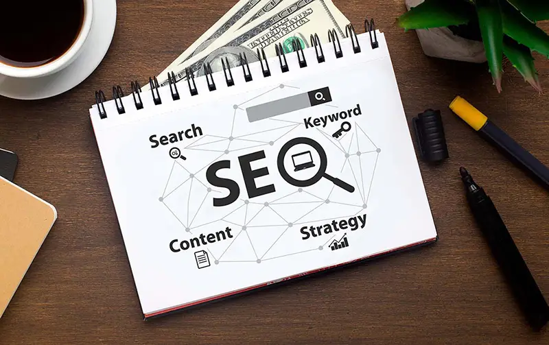 Notebook with the word 'SEO' with terms like 'Search,' 'Keyword,' and 'Strategy,' for SEO content strategy service.